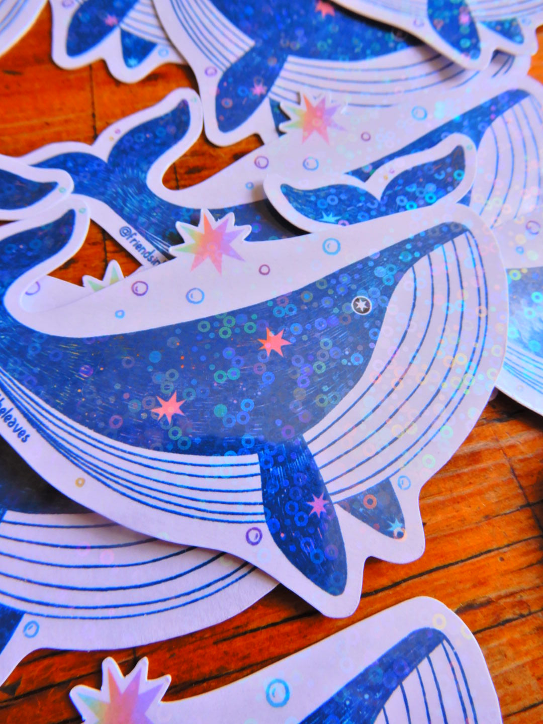 An illustrated holographic whale sticker handmade in Tasmania