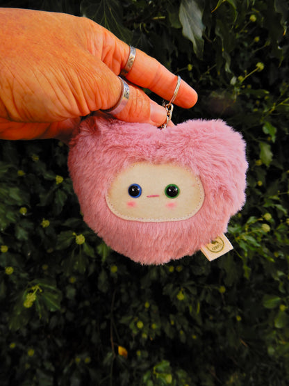 Pink plush key chain/ bag charm with a face design.