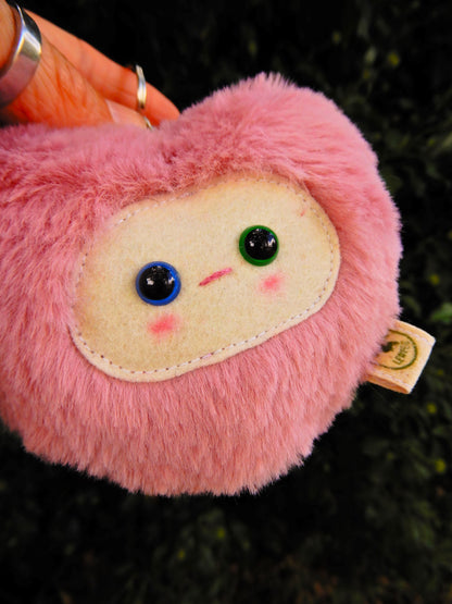 Pink plush key chain/ bag charm with a face.