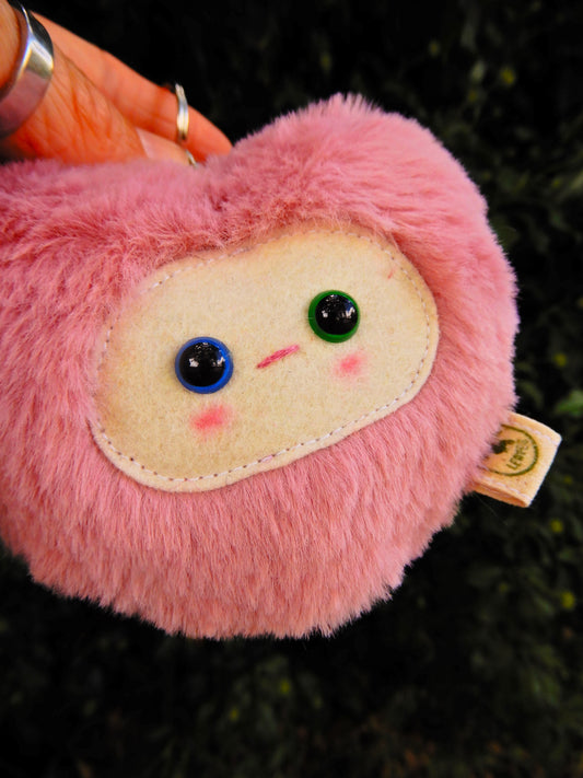 Pink plush key chain/ bag charm with a face.