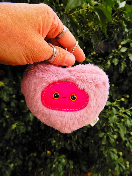 Pink heart shaped plush key chain/ bag charm with a deep pink face.